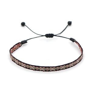 Detailed close-up of handmade ethnic braided bracelet with geometric diamond pattern