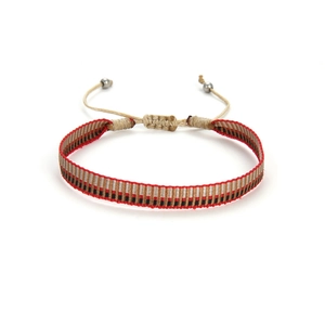 Détail du bracelet tissé rouge et noir avec motifs géométriques et nœud coulissant réglable