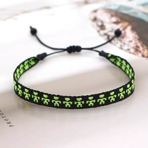 Detail of handmade woven bracelet with neon pixel art pattern and adjustable cord