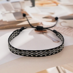 Close-up of handmade woven bracelet with geometric diamond patterns and adjustable knot