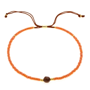 Dettaglio del bracciale regolabile con perline arancioni, pietra naturale e distanziatori