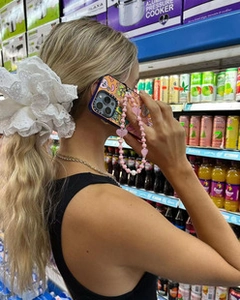 Detailed shot of white lace hair scrunchie and pink heart beaded phone charm