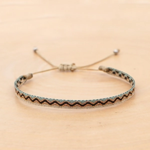 Detail of bohemian hand-woven bracelet with teal wave pattern and adjustable silver beads