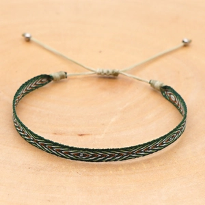 Macro view of bohemian woven bracelet with green and white geometric patterns