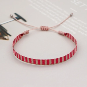 Detail of red and beige woven bracelet with adjustable cord and pink sliding knot