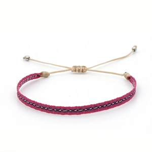 Detail of bohemian hand-woven bracelet with red and purple ethnic geometric patterns