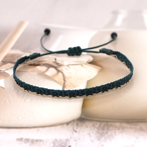 Detail of dark green hand-woven Bohemian bracelet with adjustable pull-string knot and pattern