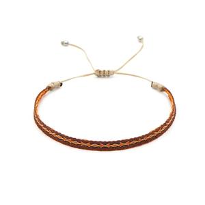 Detailed weave of ethnic handmade bracelet with orange and blue geometric patterns