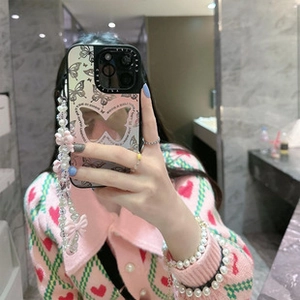 Detail view of mirror phone case with black butterfly pattern and beaded wrist strap