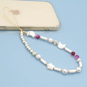 Bijou de téléphone fait main avec perles blanches, étoiles et agates roses sur un smartphone