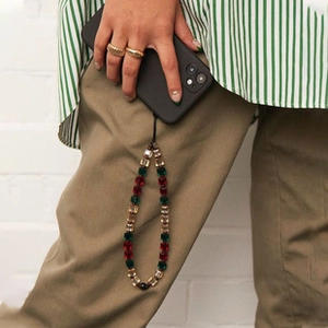Detail of colorful geometric crystal beaded phone strap with red and green beads