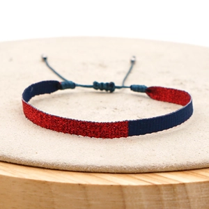 Detail of red and blue woven bohemian bracelet with metallic shimmer and adjustable cord