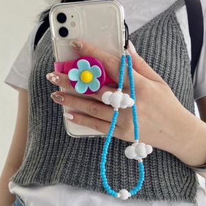 Detail showing blue beaded phone strap with cloud charm and floral pop socket