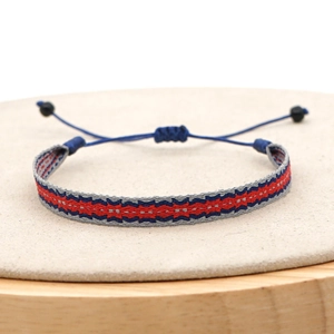 Detail of handmade woven bracelet featuring blue red and grey geometric patterns