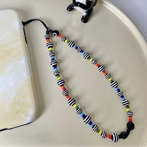 Bijou de téléphone bohème avec perles rayées et accents colorés en acrylique