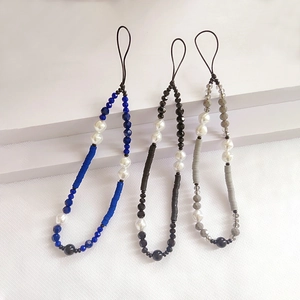 Three beaded phone straps with faux pearls and crystals on white minimalist steps