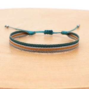 Close-up of woven bohemian bracelet in teal and orange with adjustable slider