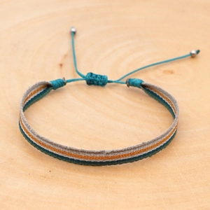 Macro shot of colorful bohemian woven bracelet on wood with adjustable silver beads