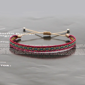 Detail of colorful hand-woven ethnic bracelet with adjustable sliding knot and silver beads