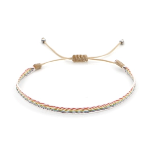 Detail of handmade woven ethnic bracelet with colorful geometric patterns and adjustable cord
