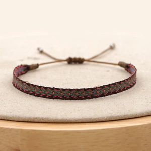 Detail of bohemian hand-woven bracelet with geometric ethnic patterns and adjustable cord