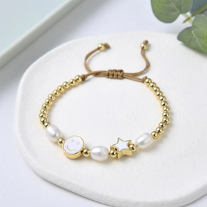 Dettaglio del bracciale con perle d'acqua dolce e perline dorate con ciondoli stella