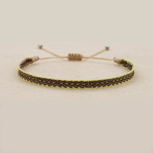 Detail of handmade woven ethnic bracelet with yellow and purple geometric patterns
