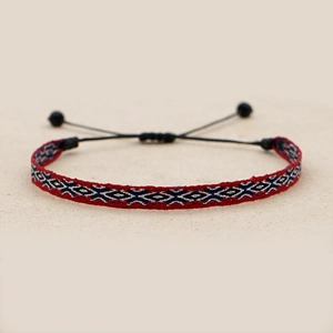 Close-up of handmade woven ethnic bracelet with red and blue geometric diamond patterns