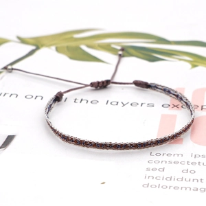 Detail of Bohemian hand-woven bracelet showing adjustable sliding knot and silver beads
