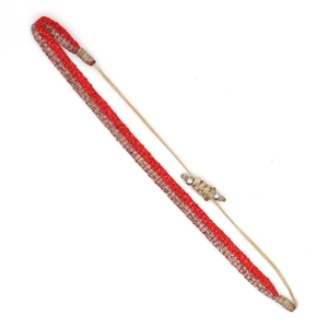 Detail of red and gold bohemian woven bracelet with adjustable cord and silver beads