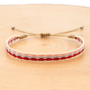 Macro shot of bohemian woven bracelet with red and silver waves and adjustable cord