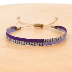 Detail view of purple bohemian woven bracelet with adjustable cord and silver beads