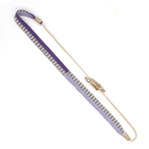 Detail of bohemian hand-woven purple and cream patterned strap with adjustable cord