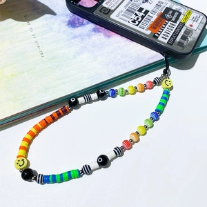 Detail of handmade beaded phone charm featuring rainbow clay discs and smiley face beads