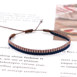 Detailed close-up of Bohemian woven bracelet with red and blue stripes and adjustable cord