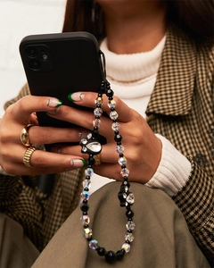 Close-up of beaded phone charm with black rabbits and crystal beads on a mobile case