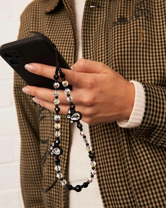 Detail of beaded phone strap featuring a black rabbit pendant and crystal beads on hand