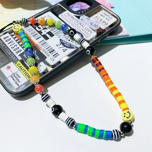Y2K style rainbow beaded phone charm with evil eye and smiley face beads on a black phone