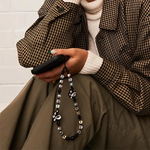 Handmade beaded phone strap with black beads and crystal flower on a stylish phone case