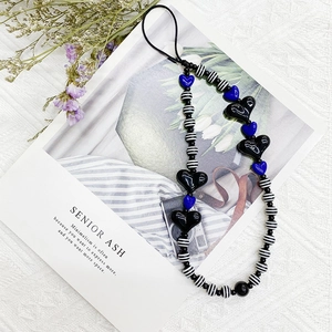 Acrylic heart and striped bead phone charm strap with black and blue accents on white background