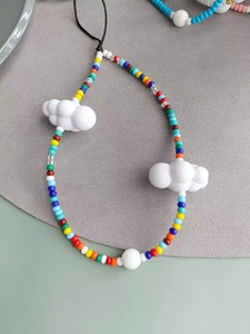 Detail of handmade beaded phone strap with colorful seed beads and white cloud charms