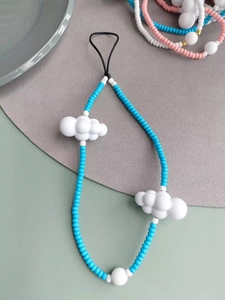 Detail of sky blue beads and white 3D cloud charms on a handmade mobile phone lanyard