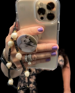 Detailed shot of beaded phone strap with pearls and black beads held with an iPhone
