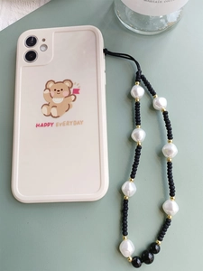 Detail of beaded phone strap with white pearls and black beads on bear print phone case