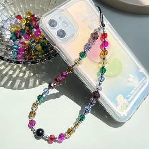 Macro shot of colorful faceted crystal beads phone lanyard attached to a floral phone case