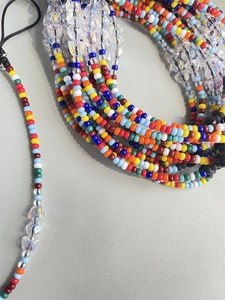 Macro shot of colorful seed beads and faceted crystal beads on a handmade phone strap
