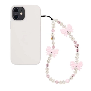 Bijou de téléphone avec nœuds roses et perles blanches sur un smartphone blanc élégant