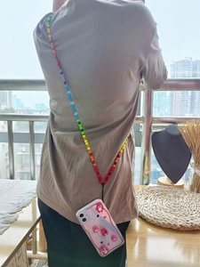 Detail of colorful rainbow beaded crossbody phone strap with a cute cartoon character case