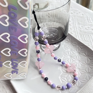 Gros plan sur la dragonne rose en perles avec cœurs et coque de téléphone LOVE