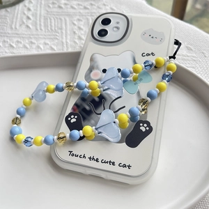 Détail de la dragonne de téléphone perlée et coque chat sur fond de crochet blanc
